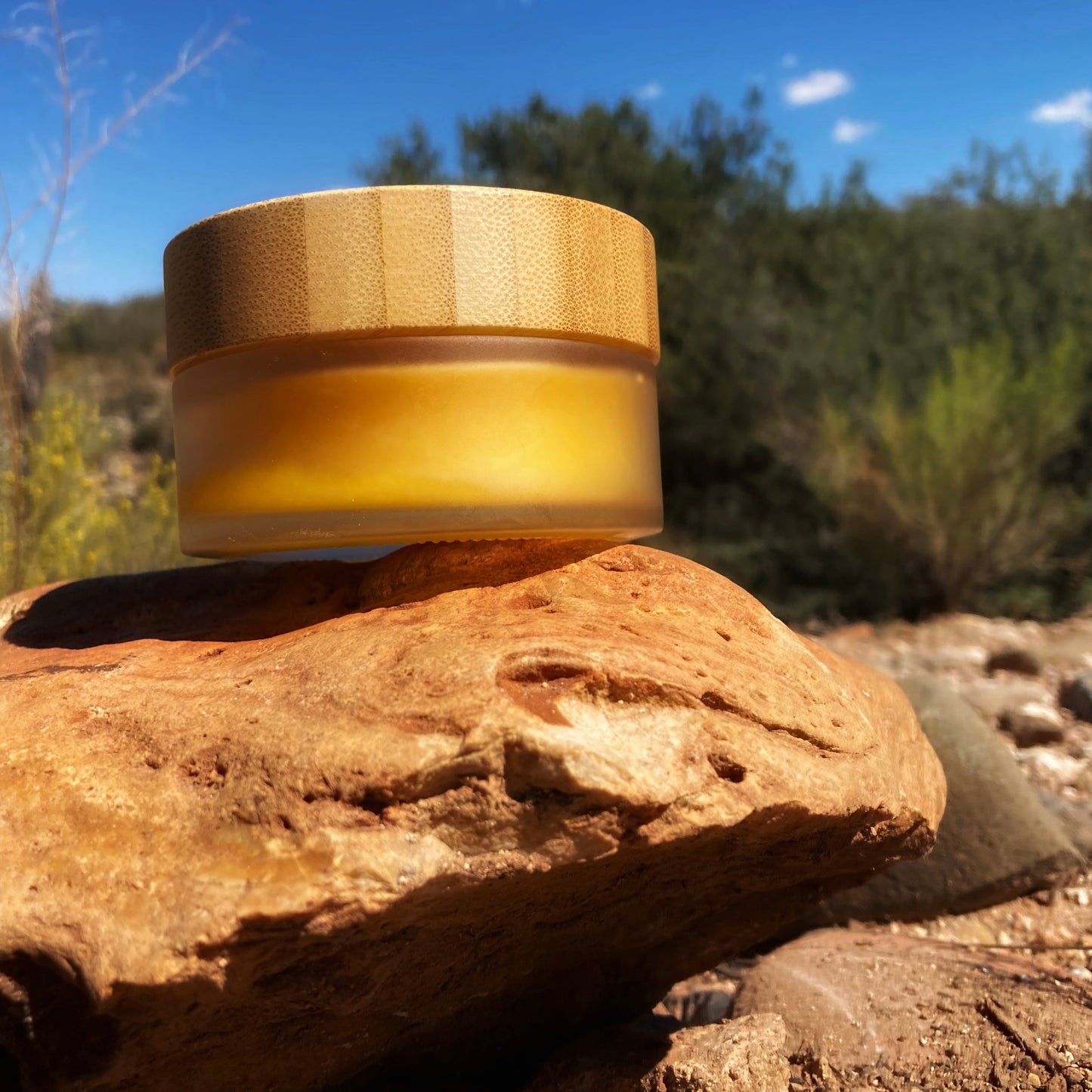 Glass jar with bamboo lid on a rock with a natural outdoor background
