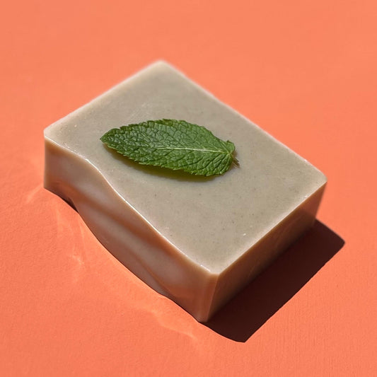 Bar of soap with a mint leaf on an orange background