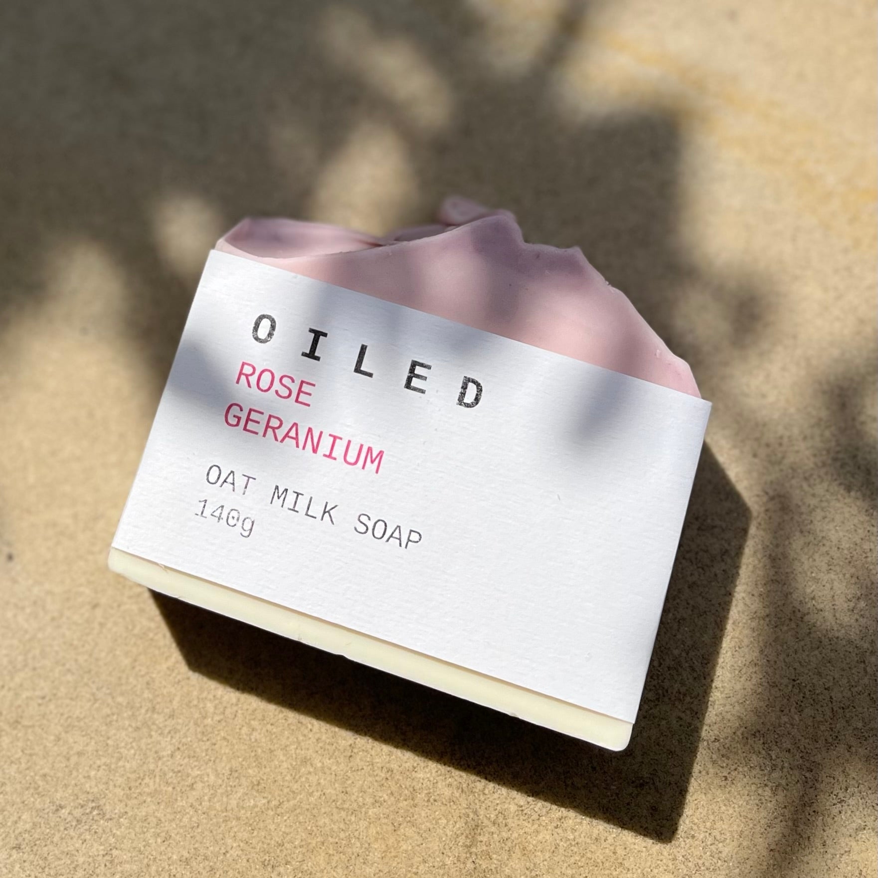 Oiled Rose Geranium oat milk soap on a textured surface
