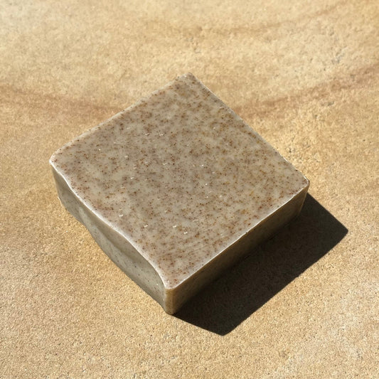 Speckled bar of soap on a sandy surface