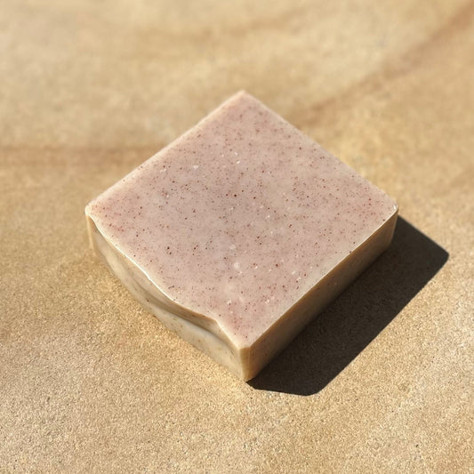 Bar of soap on a sand coloured background