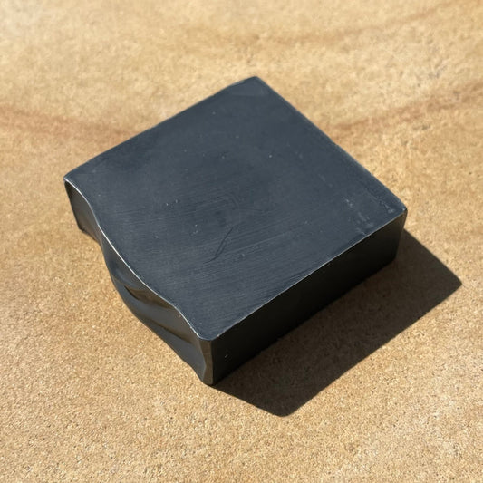 Black bar of soap on a light background.