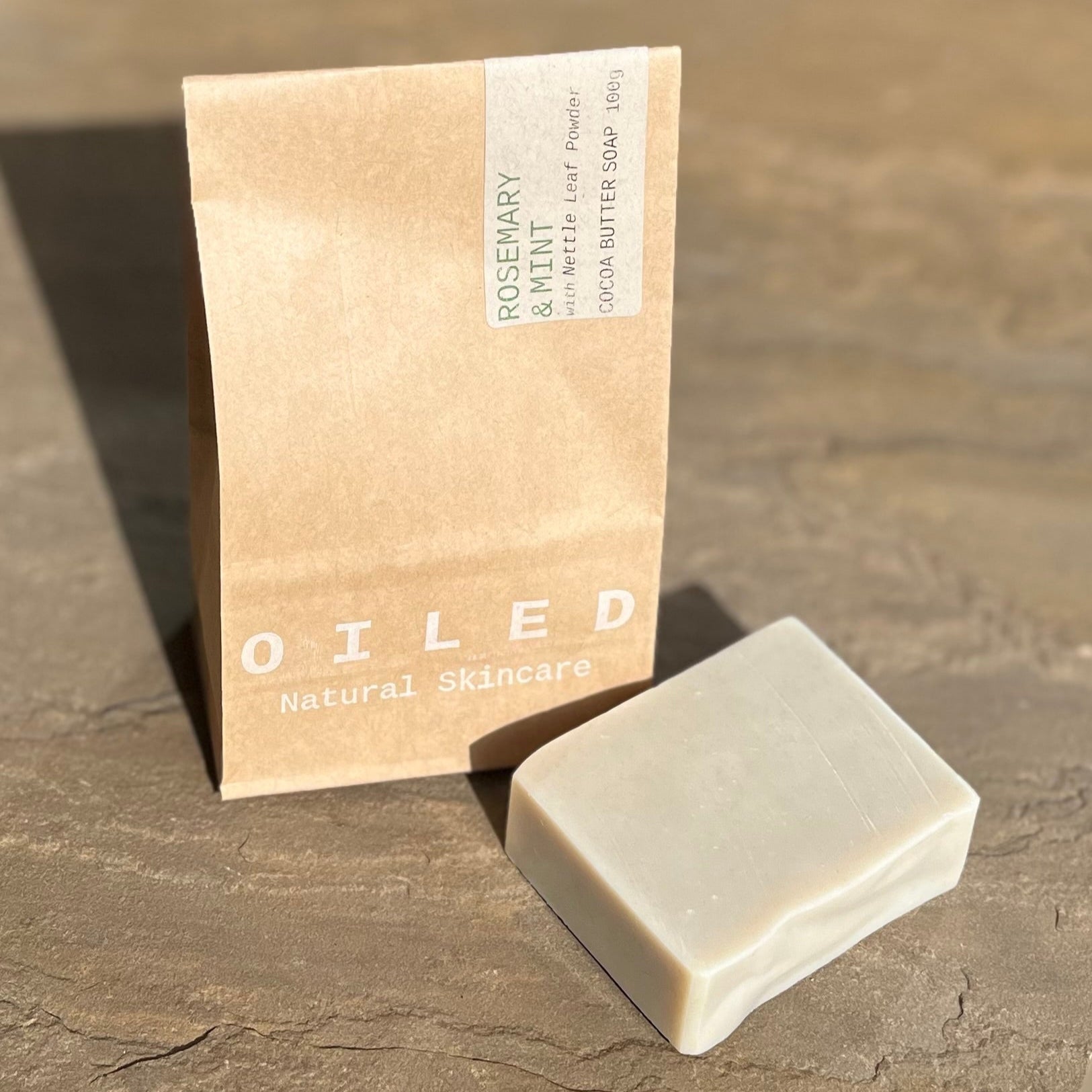 Bar of soap and its packaging labelled 'Oiled' on a stone surface