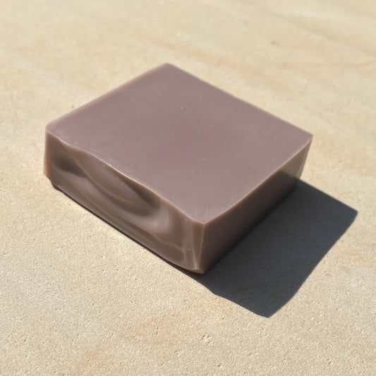 Purple bar of soap on a beige surface