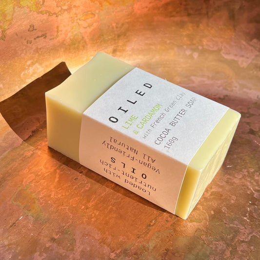 Bar of light green soap with a white label on a textured surface